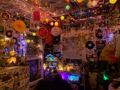 a room filled with lots of colorful lights and decorations on the ceiling above it is a bed