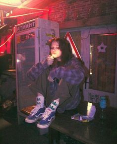 a woman sitting on top of a table next to a vending machine