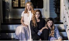 three women sitting on the steps of a house