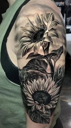 a woman's arm with sunflowers and leaves on it