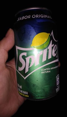 a hand holding a can of sprite soda