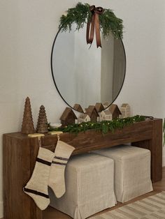 a mirror sitting on top of a wooden table next to a christmas stocking and stockings