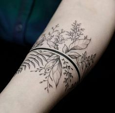 a woman's arm with a black and white tattoo design on the left forearm