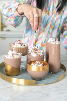 a woman is decorating desserts with sprinkles