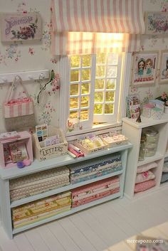 a doll house with many different items in it's display case, including quilts and fabric