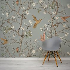 a chair in front of a wallpaper with birds and flowers on it, against a gray background