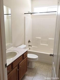 a white toilet sitting next to a bath tub in a bathroom