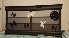 a black dresser with star wars decals on the front and side panels painted on it