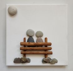 two rocks sitting on top of a wooden bench