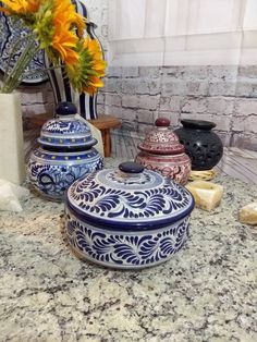 several vases with flowers in them sitting on a counter