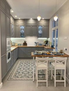 a kitchen with gray cabinets and an area rug on the floor in front of it