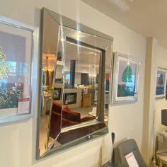 a large mirror hanging on the wall in front of a room with chairs and tables