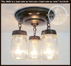 three mason jar lights hanging from a ceiling fixture