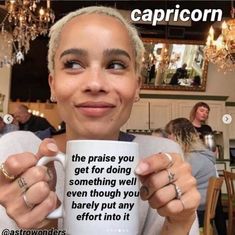 a woman holding up a coffee mug with the caption capricorn on it