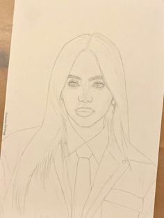 a pencil drawing of a woman with long hair and wearing a suit on top of a wooden table