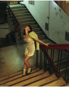 a woman standing on some stairs with her arms up