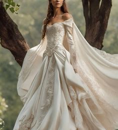 a woman in a white wedding dress standing under a tree