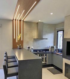 a modern kitchen with stainless steel appliances and bar stools next to the counter top