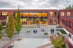 an aerial view of a building with stairs and people walking around the walkways in front of it