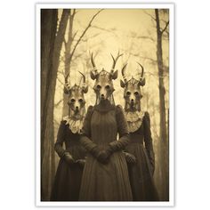 three women with horns on their heads standing in front of trees and wearing long dresses