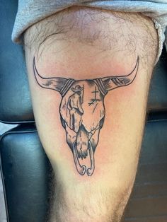 a man's leg with a bull skull tattoo on it