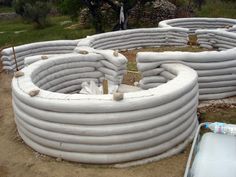 several large white pipes are laid out in the dirt