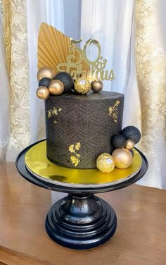 a black and gold birthday cake on a table