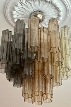 a chandelier hanging from the ceiling with multiple colored glass tubes attached to it