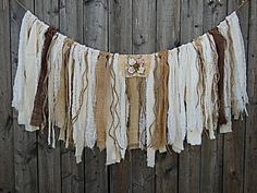 an image of a cloth banner with flowers on it hanging from the side of a wooden fence