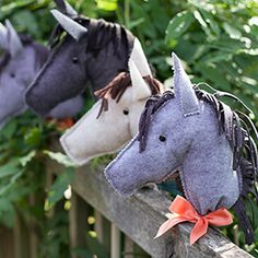 three stuffed animals are hanging on a fence