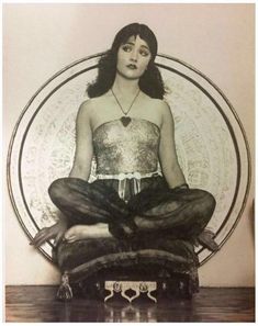 a woman sitting in the middle of a circle with her legs crossed