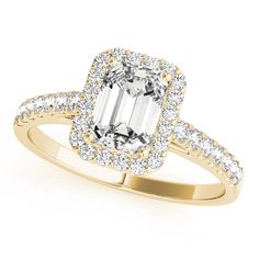 an emerald cut diamond ring with diamonds around the band and halos on each side