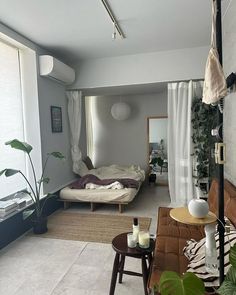 a living room filled with furniture next to a window covered in white curtained drapes