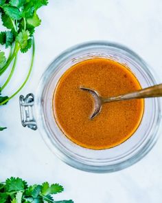 a glass bowl filled with sauce and garnished with parsley on the side