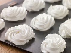 there are many white frosted cupcakes on the tray