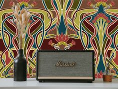 a vase with some flowers in it next to a wallpapered background and a radio