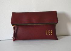 "Foldover Burgundy Clutch, Personalized Clutch Purse, Bridesmaid Gift This clutch is handcrafted from high-quality faux leather and personalized with the initials. The interior is fully lined with cotton fabric and has an inside pocket. The initials are printed in gold-tone on the bottom right corner. It can be a perfect gift for someone or for yourself. This clutch is big enough for all your most needed essentials. Our entire printed process is done by hand, using a heated press to ensure maxim Maroon Clutch, Burgundy Clutch, Personalized Clutch, Coach Leather Bag, Clutch Bag Wedding, Wedding Bags, Handmade Clutch, Wedding Clutch, Printed Clutch