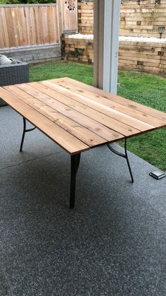 a wooden table sitting on top of a patio