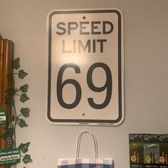 a speed limit sign mounted to the side of a wall next to a shopping bag