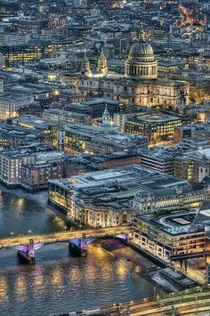 an aerial view of london at night with the river thames and st paul's cathedral in the background