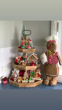 three tiered trays filled with christmas cookies and other holiday treats on top of a kitchen counter