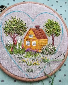 a small house in the middle of a field with trees and flowers on it's side