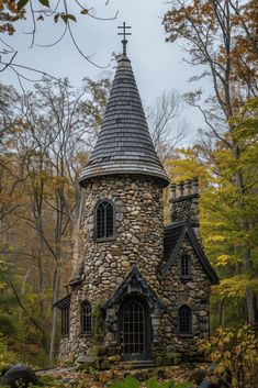 an old stone church with a steeple surrounded by trees in the fall colors and foliage