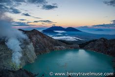 a lake surrounded by mountains with steam coming out of it's sides at dusk