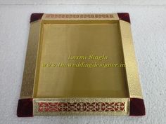 a gold and red tray on a white surface