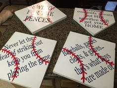 four baseball signs with words on them sitting on a counter