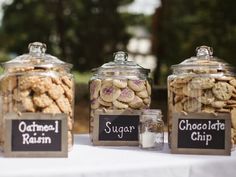 three jars filled with cookies sitting on top of a table