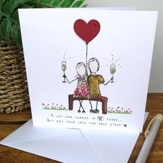 a card with an image of two people on a bench holding wine glasses and a heart shaped balloon