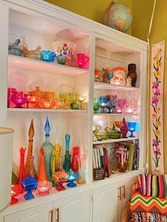 the shelves are filled with colorful glassware