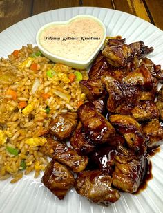 a white plate topped with meat and rice